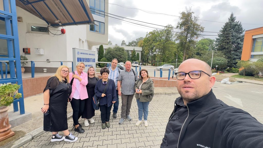 Grup de participanți în fața căminului Universitas al Universității Babeș-Bolyai, într-un moment de socializare la finalul unei întâlniri.